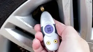 person using tyre pressure gauge